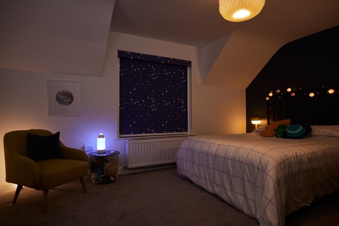 A young girl asleep in a dim bedroom with a nightlight on